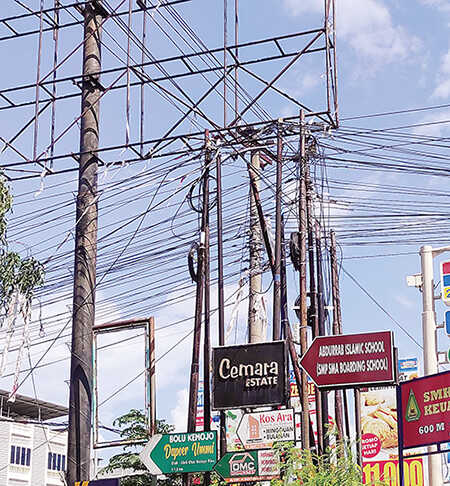 MENUMPUK: Kabel FO menumpuk di tiang jaringan persimpangan Jalan Bakti-Jalan Soekarno Hatta, membuat kesan kabel dipasang semrawut. Foto diambil Rabu (6/8/2025) lalu. MHD AKHWAN/RIAUPOS
